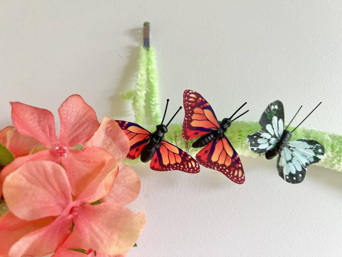 Artificial butterflies and flowers attached to a wall as decoration.
