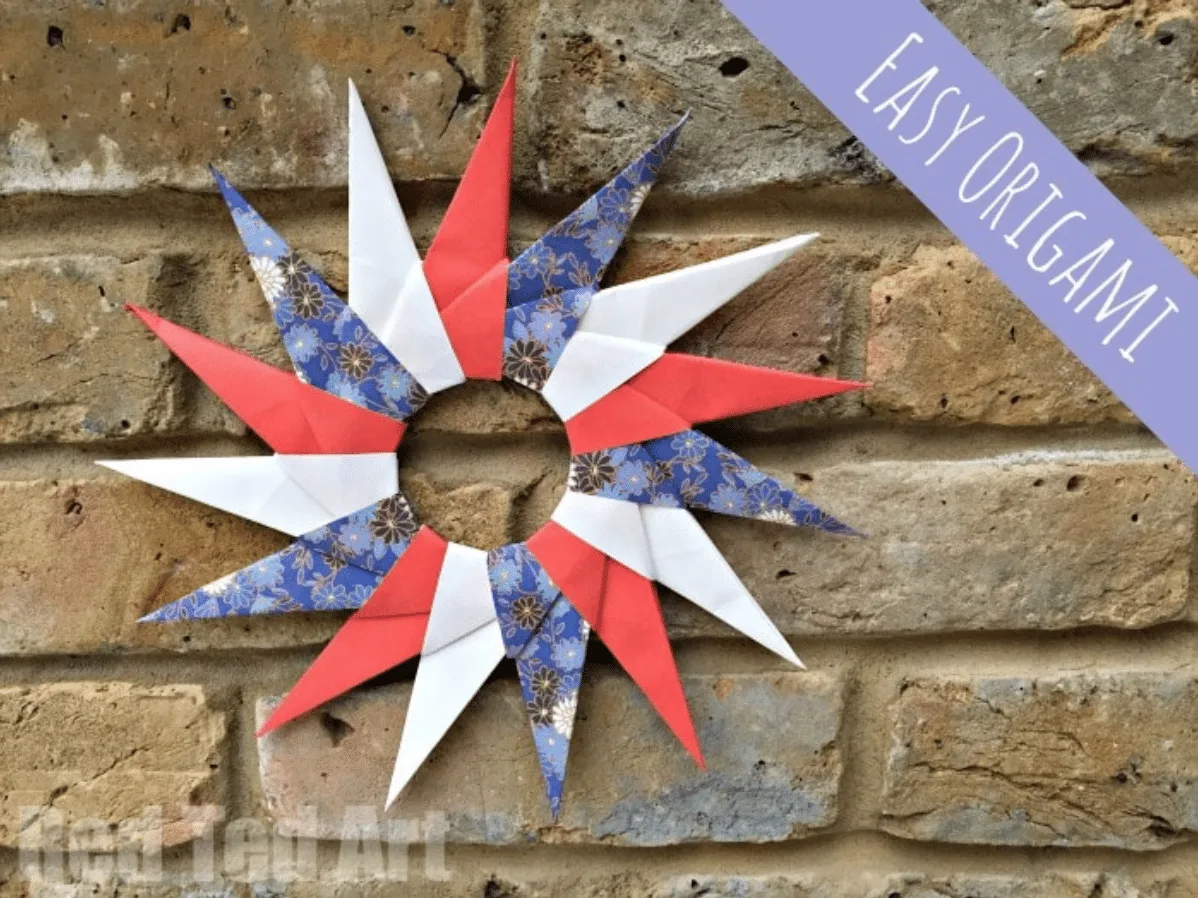 A colorful paper origami star decoration mounted on a brick wall with a label saying "easy origami.