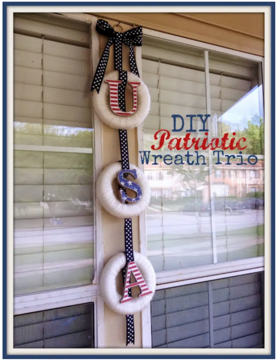 A handmade Fourth of July wreath trio featuring the letters "u," "s," and "a," displayed on a window with a polka-dot ribbon.