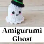 A small crocheted amigurumi ghost with a black hat rests on a wooden surface. Text above and below the ghost reads, "Amigurumi Ghost FREE Crochet Pattern." Website name at the top.