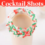 A sugar cookie cocktail shot with a rim decorated with red, green, and white sprinkles.