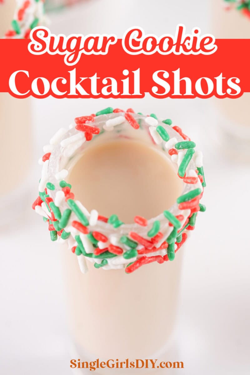 A sugar cookie cocktail shot with a rim decorated with red, green, and white sprinkles.