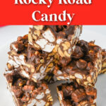 Six pieces of rocky road candy stacked on a plate.