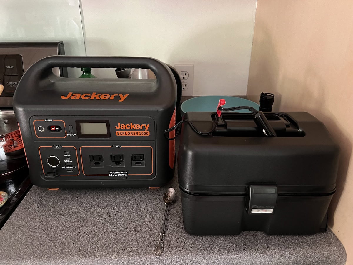 Portable power station and black toolbox on a countertop, with a spoon nearby.