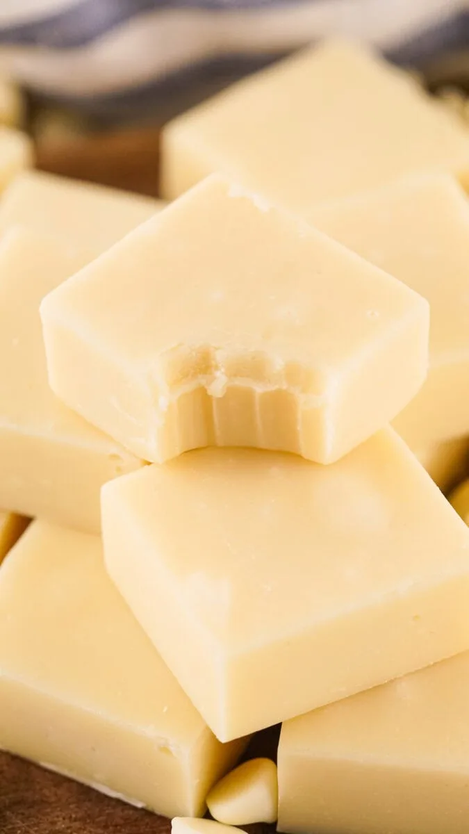 Close-up of stacked white chocolate squares with a bite taken out of the top piece.