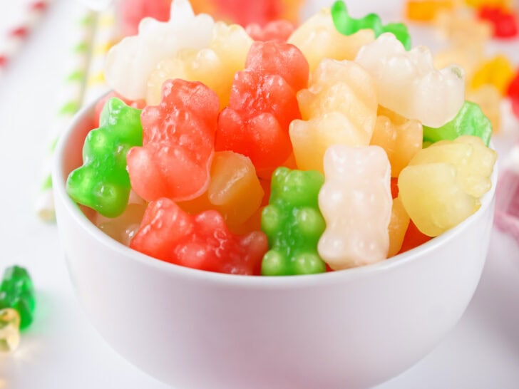 A white bowl filled with colorful frozen gummy bears, mostly red, green, white, and yellow.