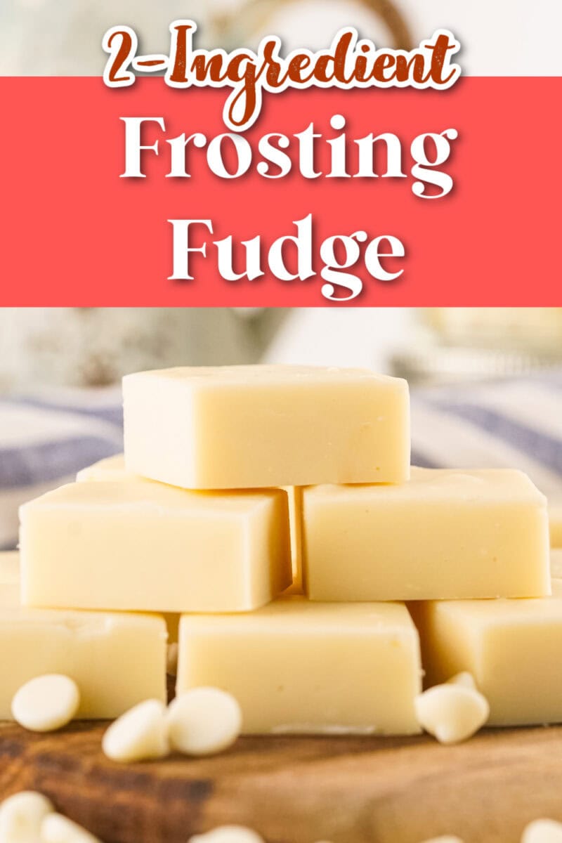 A stack of vanilla frosting fudge squares is placed on a wooden board, with white chips scattered around. The image is titled "2-Ingredient Frosting Fudge.