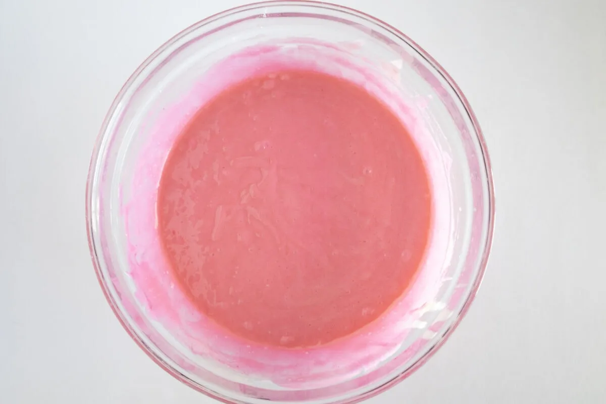 A glass bowl filled with smooth, pink liquid, viewed from above.