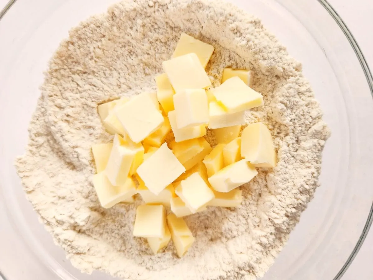 Cubes of butter placed in a bowl of flour, ready for mixing.