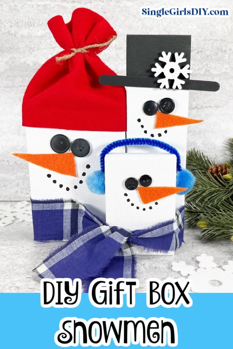 Three DIY snowmen made from gift boxes. They have button eyes, orange carrot noses, and winter accessories such as hats and scarves. Text reads "DIY Gift Box Snowmen.