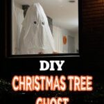 A white sheet with cut-out eyes draped over a Christmas tree creates a ghost figure in a window, promoting a DIY Halloween decoration idea.
