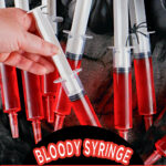 Several plastic syringes filled with red Jell-O are arranged on a dark fabric, with one hand holding a syringe. Text reads, "Syringe Jello Shots Bloody Syringe Jell-O Shots SingleGirlsDIY.com.