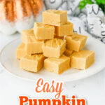 pumpkin fudge squares piled high on a white plate with a sparkly orange pumpkin in the background