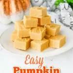 pumpkin fudge squares piled high on a white plate with a sparkly orange pumpkin in the background