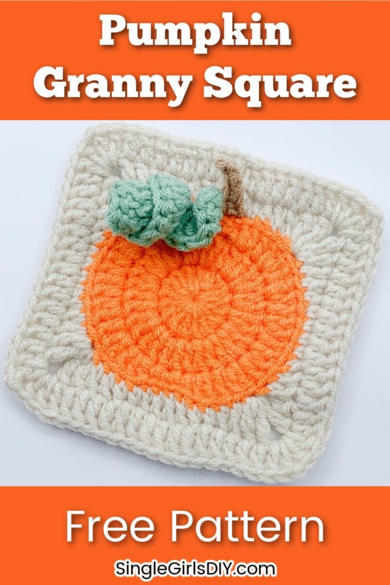 Crocheted granny square featuring an orange pumpkin with a green stem on a cream background. Text reads "Pumpkin Granny Square Free Pattern SingleGirlsDIY.com".
