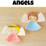 Two paper angels made from cupcake liners with drawn faces and golden hairbands, one in pink and one in blue, displayed on a wooden surface.