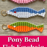 Three colorful fish-shaped keychains made of pony beads and gold key rings are displayed on a wooden surface. Text reads &ldquo;Pony Bead Fish Keychain Free Pattern!&rdquo;.