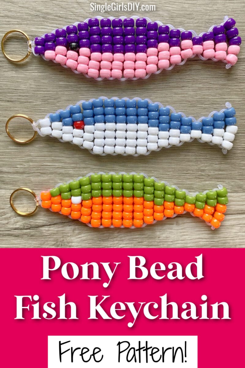 Three colorful fish-shaped keychains made of pony beads and gold key rings are displayed on a wooden surface. Text reads &ldquo;Pony Bead Fish Keychain Free Pattern!&rdquo;.